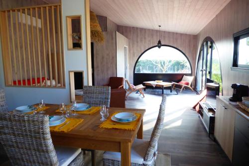 un salon avec une table et des chaises en bois dans l'établissement La villa Ponta, au calme proche plage, à Vaux-sur-Mer