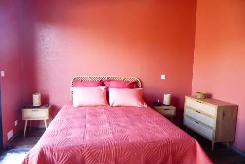 une chambre rouge avec un lit avec des draps roses dans l'établissement La villa Ponta, au calme proche plage, à Vaux-sur-Mer