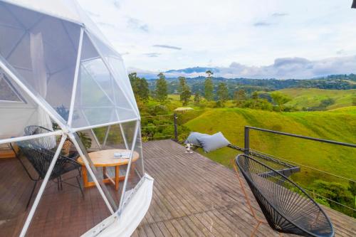 a balcony of a yacht with a table and chairs at Ecohotel Monte Tierra Habitaciones y Glamping in Filandia