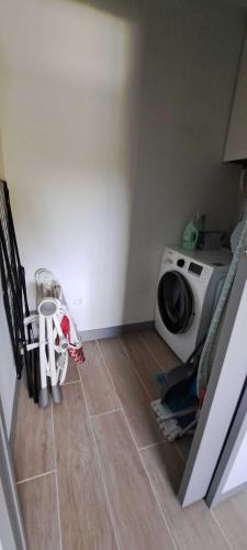 a laundry room with a washing machine and a tiled floor at Pacific Green-80M2-Clime-2 big Suites-Parking privé 2 cars-Jardin-Confort in Chalifert