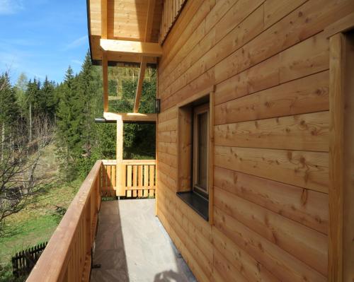 a wooden house with a balcony and a window at ALMNEST - LACHTAL in Lachtal