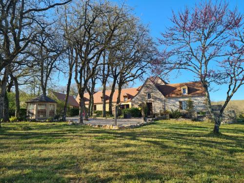 une ancienne maison en pierre dans un champ arboré dans l'établissement Domaine de Nineyrolle, à Azerat