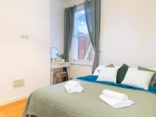 a bedroom with a bed with towels on it at Broomsleigh NW6 Apartment in London