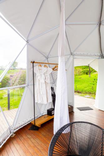 a tent with a dress hanging in it at Ecohotel Monte Tierra Habitaciones y Glamping in Filandia