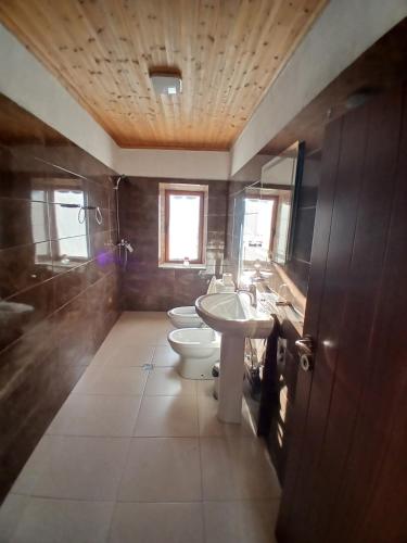 a bathroom with two toilets and a sink and a tub at Bujtina Tusha in Tirana