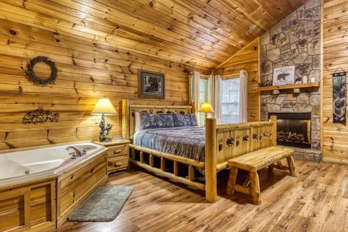 a log cabin bedroom with a bed and a tub at Suite Sensations in Pigeon Forge