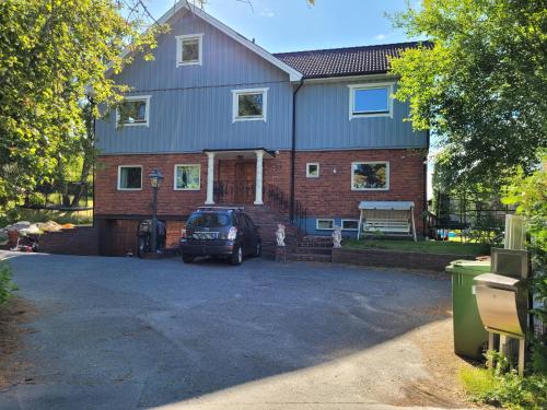 a house with a car parked in front of it at Spacious home in idyllic neighbourhood, 15min to City in Sollentuna
