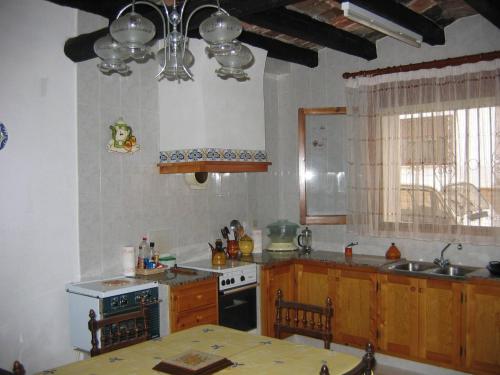 a kitchen with a table and a stove top oven at Casa De Maestro, costa Dorada in Alcanar