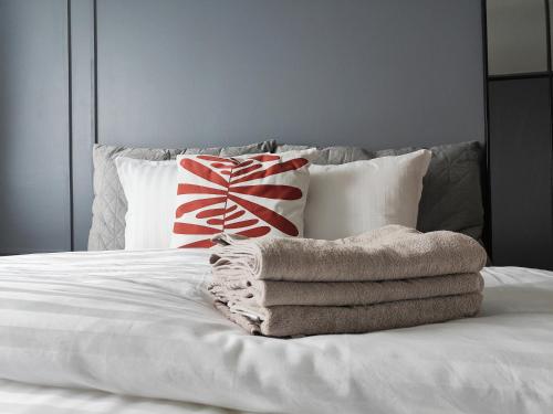 uma pilha de toalhas sentadas em cima de uma cama em Modern&Quiet 7th floor Apt with Balcony, Free 5G WIFI, Laukontori em Tampere
