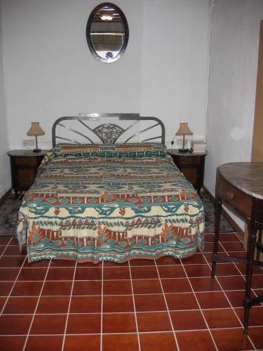 a bedroom with a bed and two tables and a mirror at Casa De Maestro, costa Dorada in Alcanar