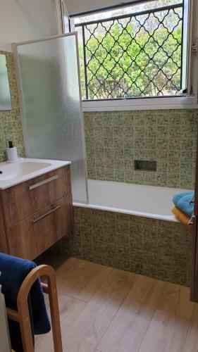 une salle de bain avec une douche et un lavabo et une fenêtre dans l'établissement Villa Les écureuils, à Lacanau