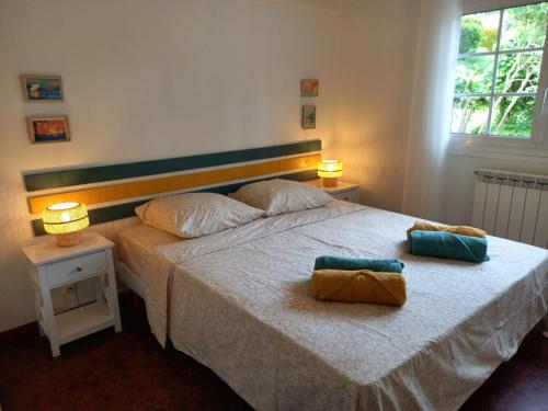 une chambre avec un lit avec deux oreillers dessus dans l'établissement Villa Les écureuils, à Lacanau