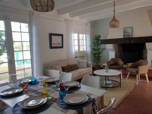 un salon avec une table et un canapé dans l'établissement Villa Les écureuils, à Lacanau