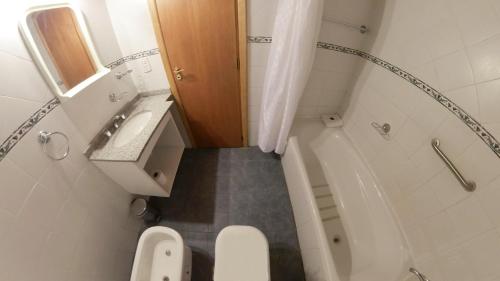 a small bathroom with a toilet and a sink at Apart Hotel del Pellin in San Martín de los Andes