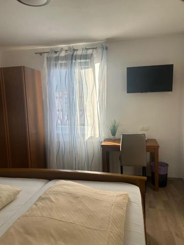 a bedroom with a bed and a window and a desk at Bed and Breakfast - Rheingauer Hof in Oestrich-Winkel