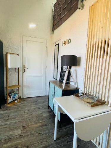 un salon avec une table blanche et une lampe dans l'établissement Studio climatisé tout confort à 100 m de la plage, à Lumio