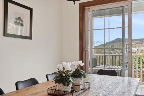 a dining room with a table with white flowers on it at Tremblant Prestige - Manoir 120-6 in Mont-Tremblant