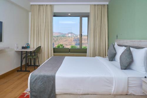 a bedroom with a large white bed and a window at Ikshana Resort and Spa, Khandala in Lonavala