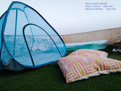 een tent en een bed op het gras bij Stay At The Home in Varanasi