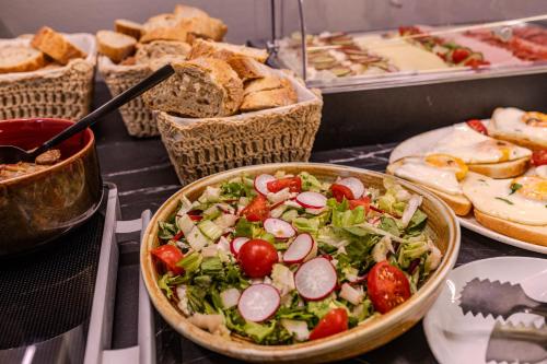 a salad in a bowl on a table with bread at La Maison de Caroline in Alba Iulia