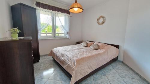 sypialnia z łóżkiem i oknem w obiekcie Międzyzdroje Apartament Muszelka Centrum Blisko Morza w mieście Międzyzdroje