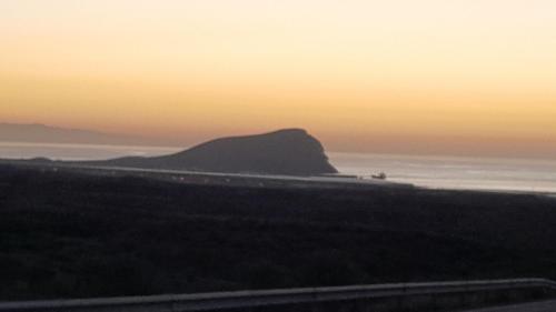 a view of a mountain in the ocean at sunset at Los Abrigos 2 apartments Guest House Ocean relax, wifi, playas in Los Abrigos