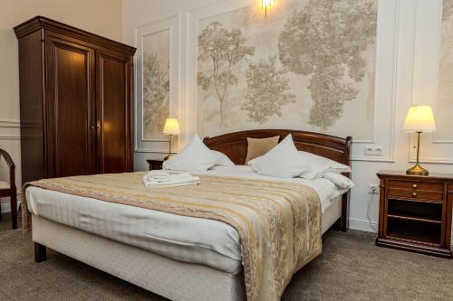 a bedroom with a large bed with a wooden headboard at La Maison de Caroline in Alba Iulia