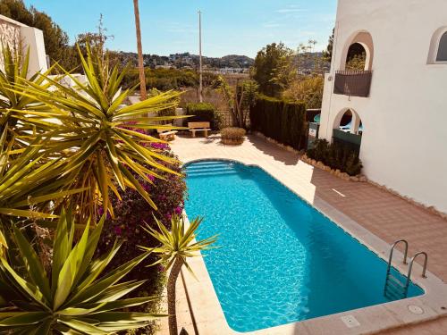 una piscina frente a una casa con plantas en Arenal Dream Javea, luxury beach apartment, en Jávea