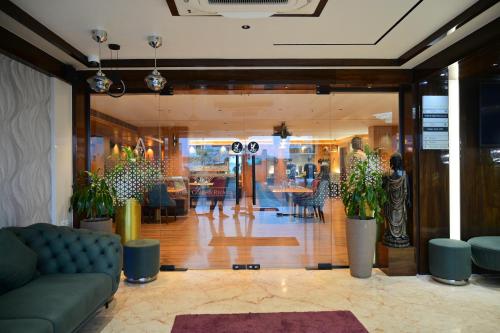 a lobby with a couch and tables and chairs at Hotel Golden Riviera in Mysore