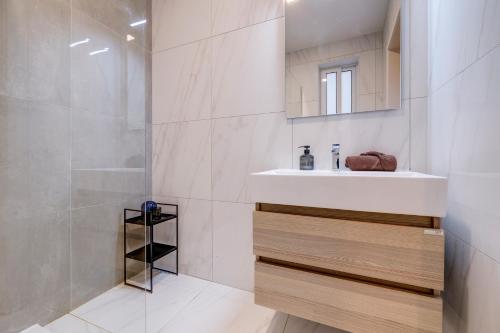 スリーマにあるModern Gem Central Sliema Steps to Valletta Ferryの洗面台とシャワー付きのバスルーム