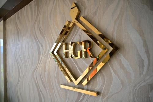 a wooden hrh sign hanging on a wall at Hotel Golden Riviera in Mysore