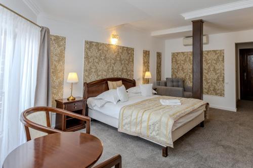 a hotel room with a bed and a table at La Maison de Caroline in Alba Iulia