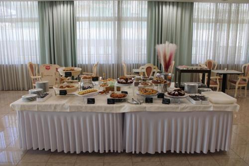 a table with food on it in a room at Hotel Royal Plaza in Rimini