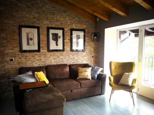 a living room with a brown couch and a chair at La casa de Sara in Novés de Segre