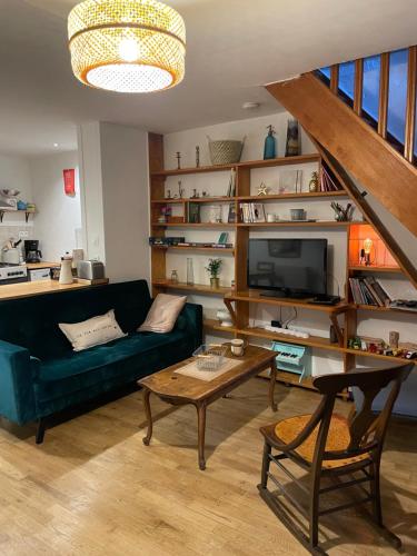 ein Wohnzimmer mit einem Sofa und einem Tisch in der Unterkunft Ô Bonheurs Simples d'Ecorsaint Ici Doucement in Hauteroche