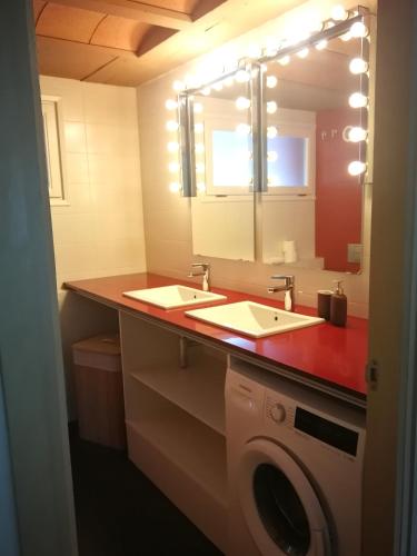 a bathroom with two sinks and a washing machine at La casa de Sara in Novés de Segre
