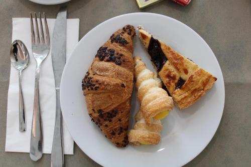 a white plate with a sandwich and waffles on it at Hotel Royal Plaza in Rimini