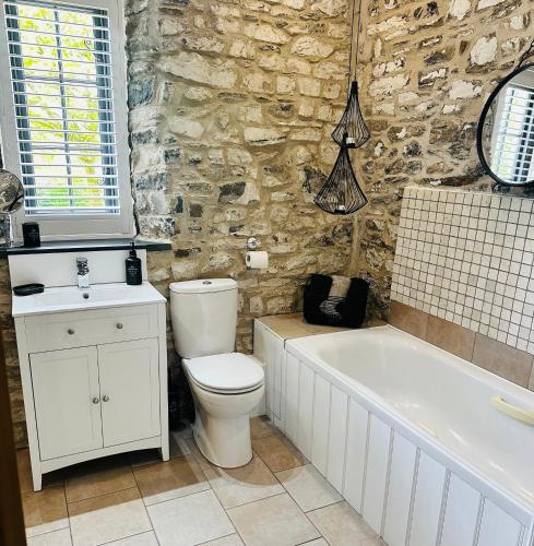 a bathroom with a toilet and a tub and a sink at Captain‘s Cottage in Llandeilo