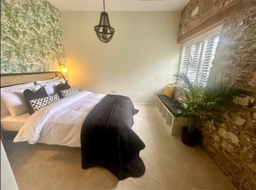 a bedroom with a large bed and a potted plant at Captain‘s Cottage in Llandeilo