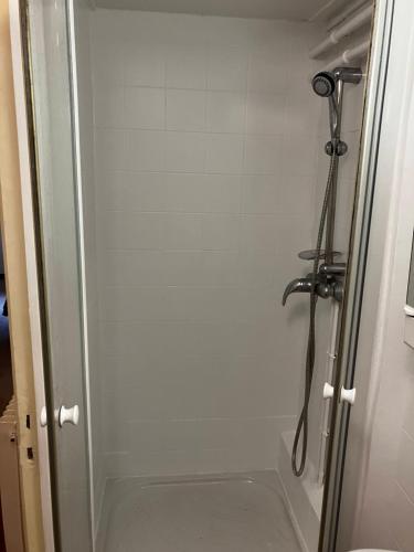 une douche dans une salle de bain avec une porte vitrée dans l'établissement Studio dans maison avec jardin, à Rueil-Malmaison