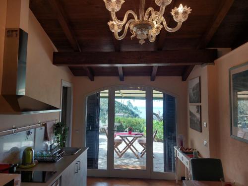 eine Küche mit einem Kronleuchter und einer Tür zu einer Terrasse in der Unterkunft Incanto in Vernazza