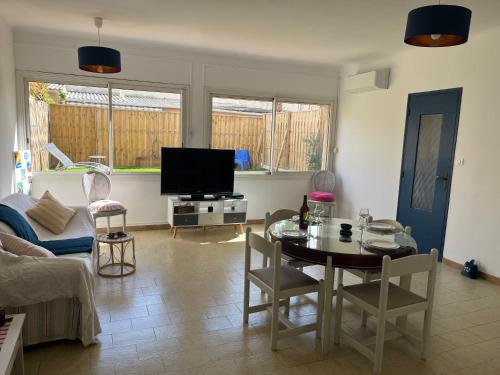 un salon avec une table et une télévision dans l'établissement Villa Augustine Marseille Bonneveine 8éme, à Marseille
