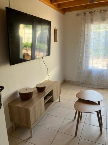 a living room with a tv on the wall at Gîte des champs fondus in Picauville