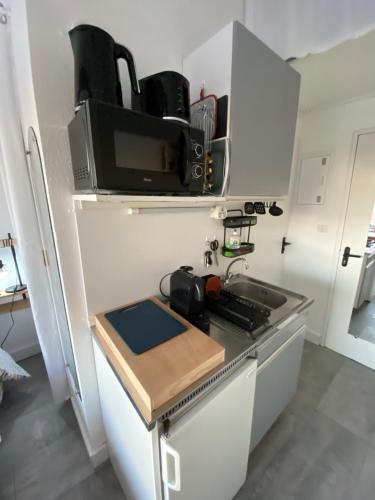 une petite cuisine avec un micro-ondes et une cuisinière dans l'établissement Studio Village Naturiste, au Cap d'Agde