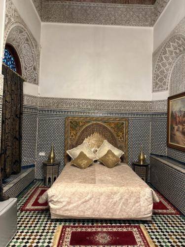 Riad Damia Suite &Spa في فاس: غرفة نوم بسرير كبير في غرفة