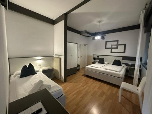 Cette grande chambre comprend 2 lits et un miroir. dans l'établissement Athos Hotel, à Riva del Garda