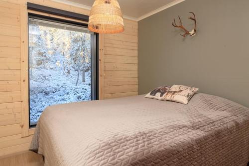 a bedroom with a bed and a large window at Näköalahuoneisto Iso-Syöte Ketunpolku in Syöte