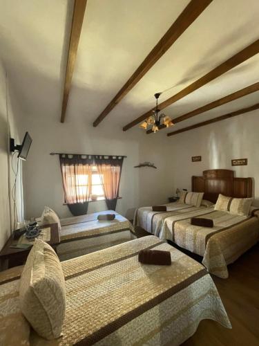 una camera con tre letti e un soffitto di La magnolia a La Puerta de Segura