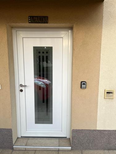 a white door in a building with a sign above it at Apartma Azurre in Postojna