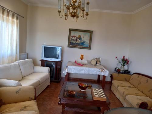 a living room with a couch and a tv at THEO house in Kyllini Zakynthos in Kyllini